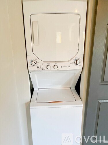 A white washing machine with a grey door and a grey handle.