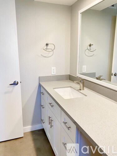 A bathroom with a sink, mirror, and cabinets.