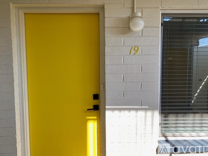 A yellow door is on the left and a white wall with a number 19 on it is on the right.
