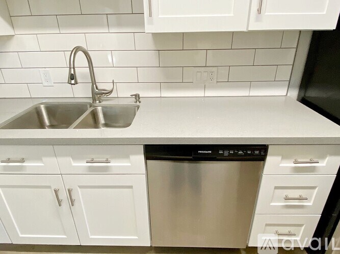 A kitchen with white cabinets and a stainless steel dishwasher.