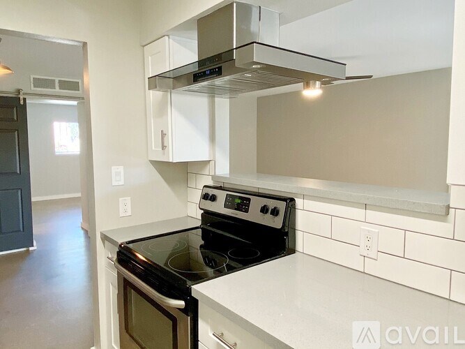 A modern kitchen with a stove top oven and a range hood.