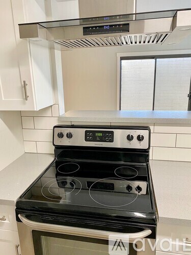 A black stove top oven with four burners and a digital display.