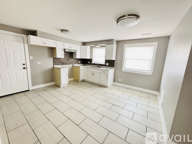 A kitchen with a tile floor and white appliances.