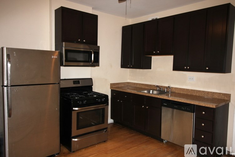 A kitchen with black cabinets and stainless steel appliances.
