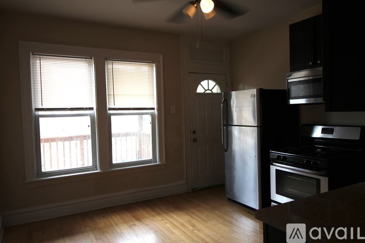 A kitchen with a stainless steel refrigerator and black cabinets.