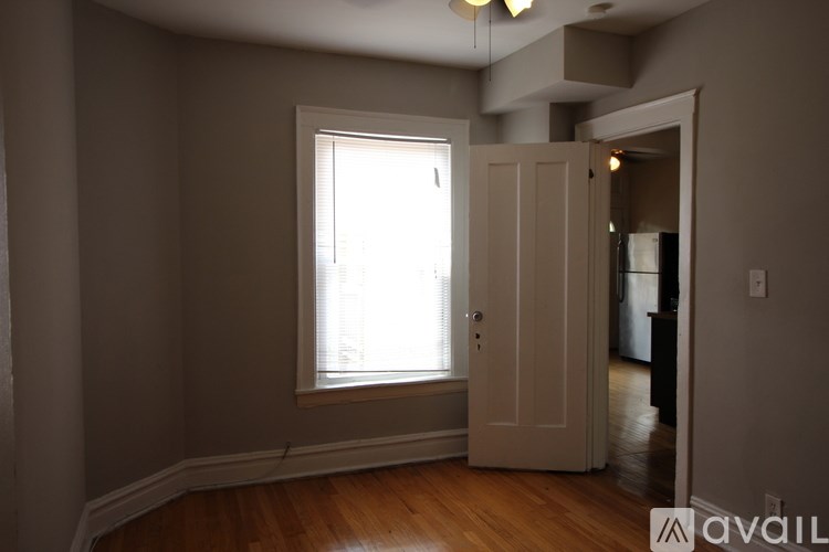A room with a window and a door leading to another room.