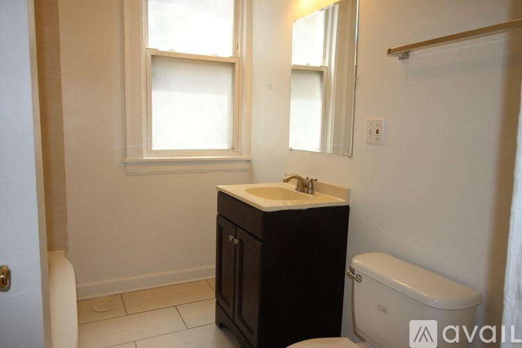 A bathroom with a sink, toilet, and a window.