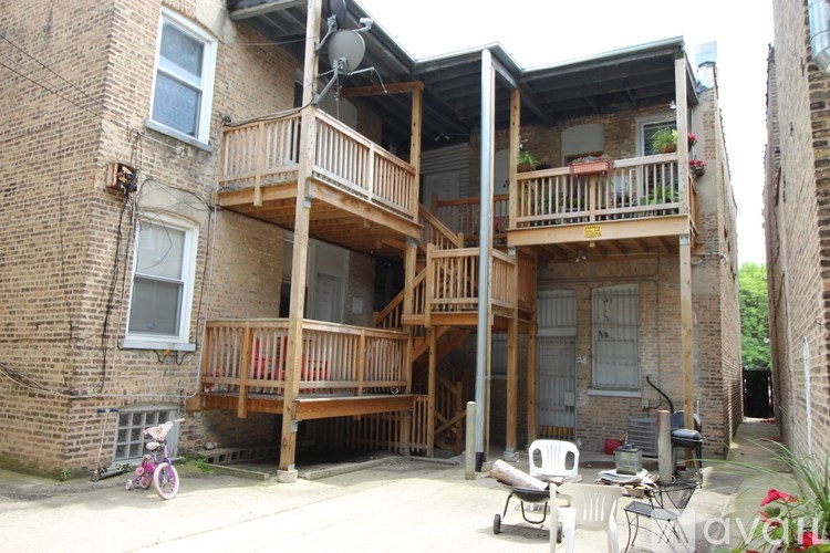 A multi-story apartment building with a balcony and a bicycle parked outside.