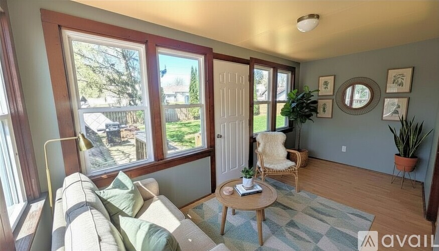 A room with a ceiling fan and a window overlooking a parking lot.