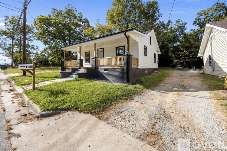A mobile home with a gravel driveway and a wooden fence.