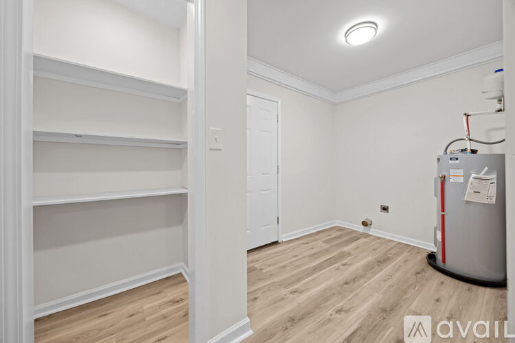 A room with a wood floor and a wall of shelves.