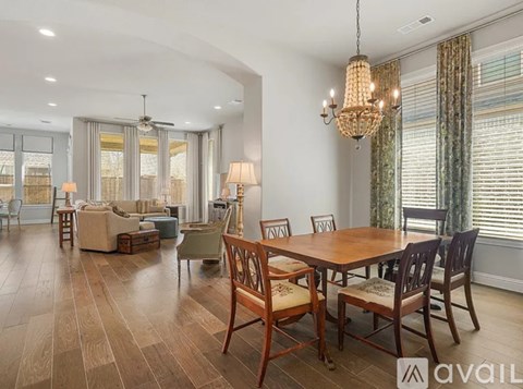 A well-lit dining room with a wooden table and chairs.