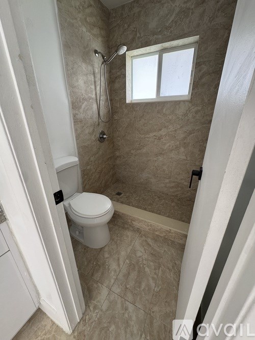 A bathroom with a toilet, sink, and shower.