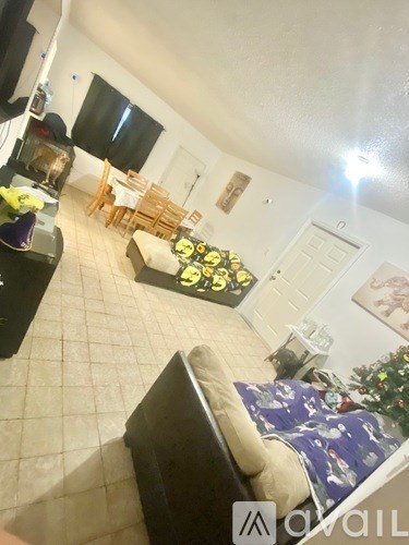 A living room with a couch, a coffee table, and a television.