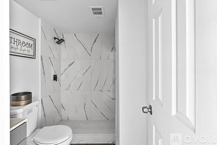 A bathroom with a toilet, sink, and shower.