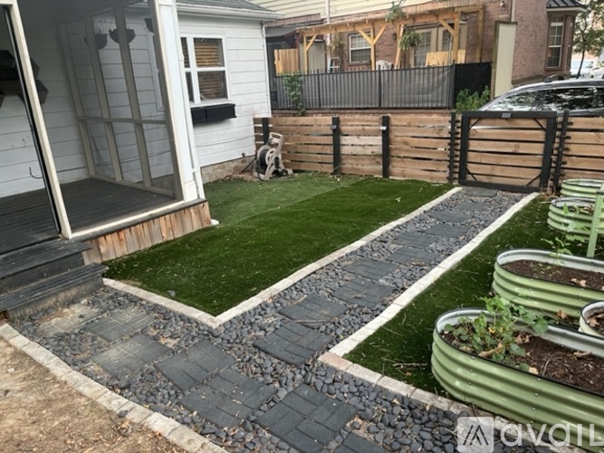 A backyard with a wooden deck, a small garden, and a fence.