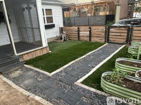 A backyard with a wooden deck, a small garden, and a fence.