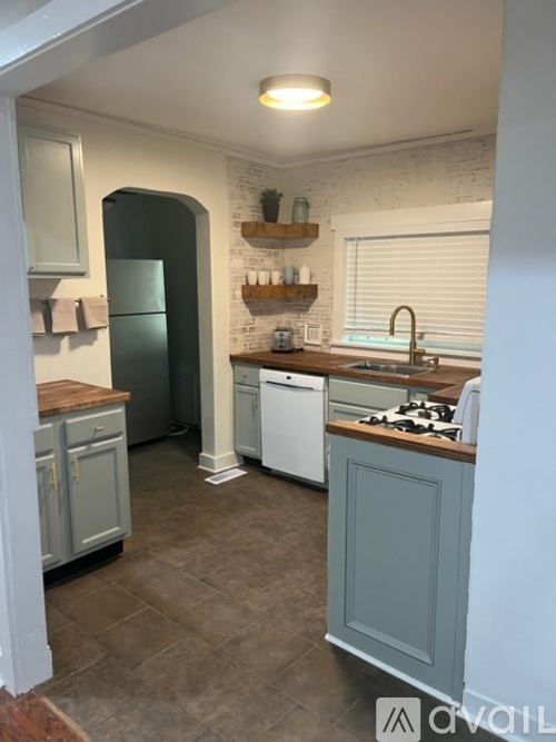 A kitchen with a white fridge and a white dishwasher.