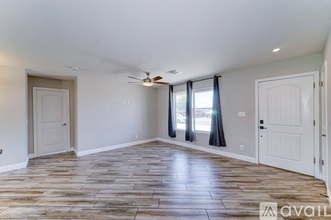 A room with wooden flooring and a ceiling fan.