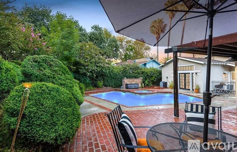 A backyard with a pool and patio furniture.