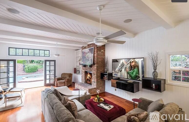 A living room with a couch, a fireplace, and a television.