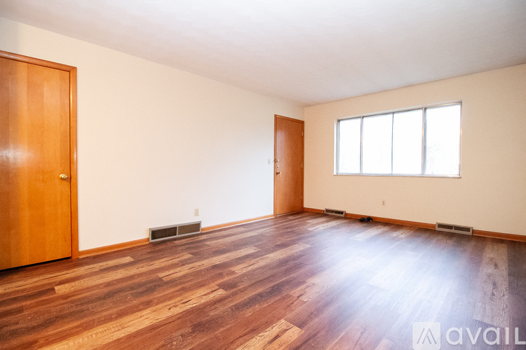 A room with wooden floors and a large window.
