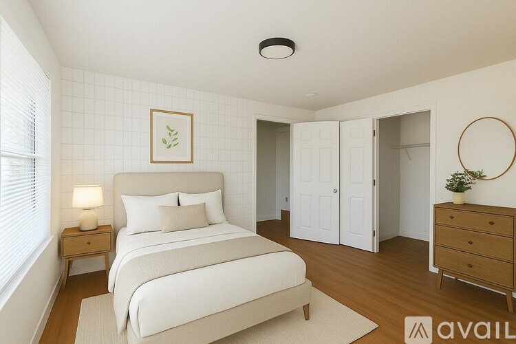 A bedroom with a large bed, a nightstand, and a dresser.