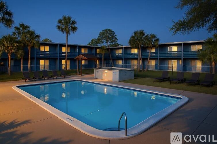 A swimming pool in front of a building with palm trees.