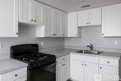 A kitchen with white cabinets and a black stove top.