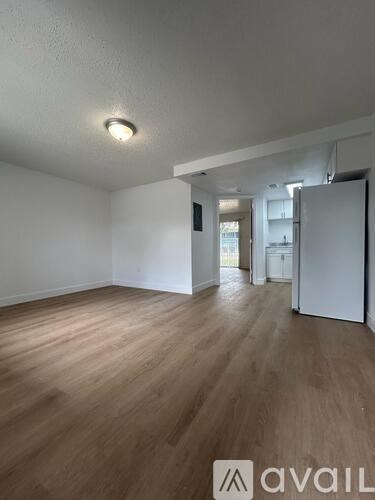 A room with wooden flooring and a white wall.
