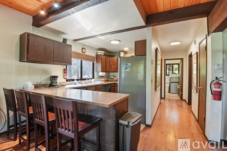 A kitchen with wooden chairs and a counter.