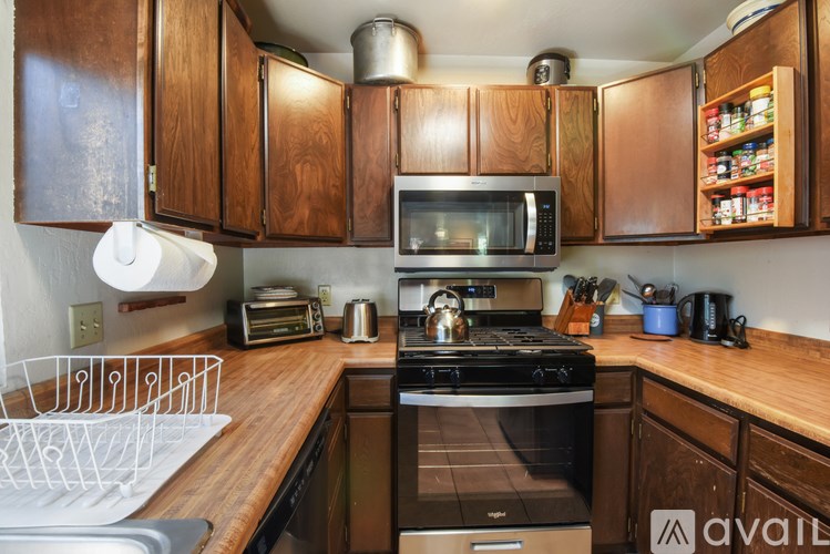 A kitchen with wooden cabinets and a stove top oven.