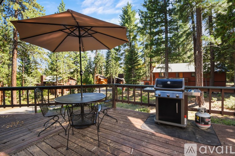 A patio with a table, chairs, and an umbrella.