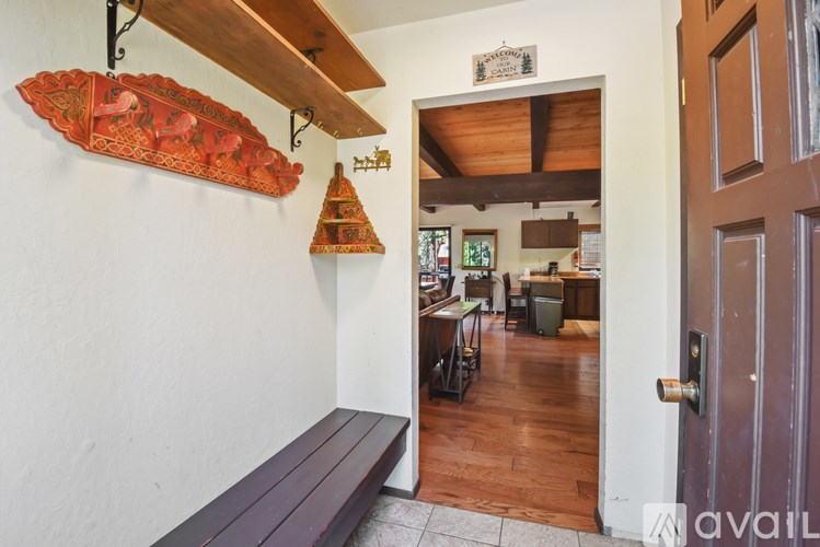 A hallway with a wooden bench and a wooden ceiling.