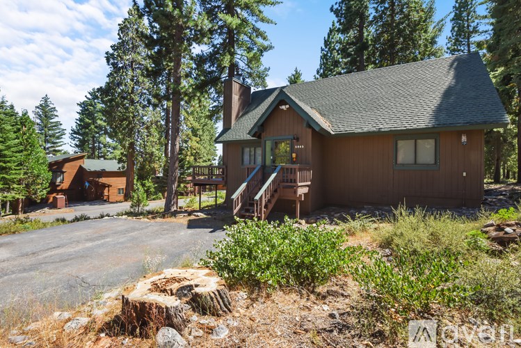 A house with a brown roof and a green lawn in front of it.