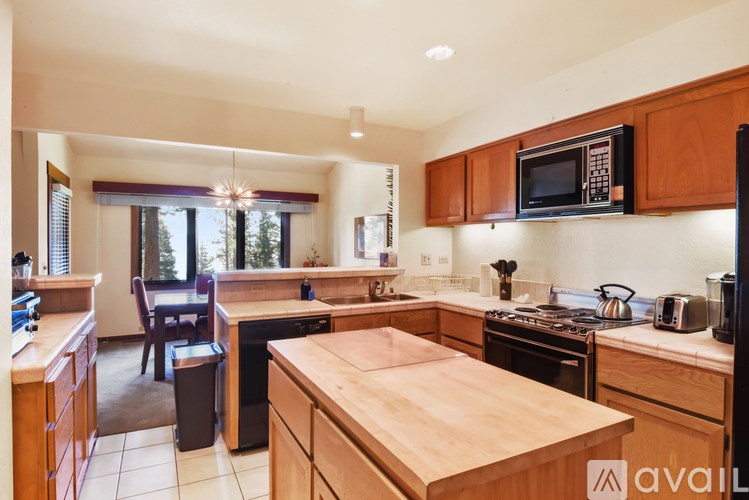 A kitchen with wooden cabinets and a wooden island.