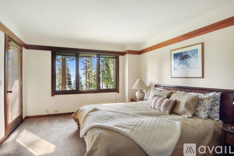 A bedroom with a large bed and a painting on the wall.