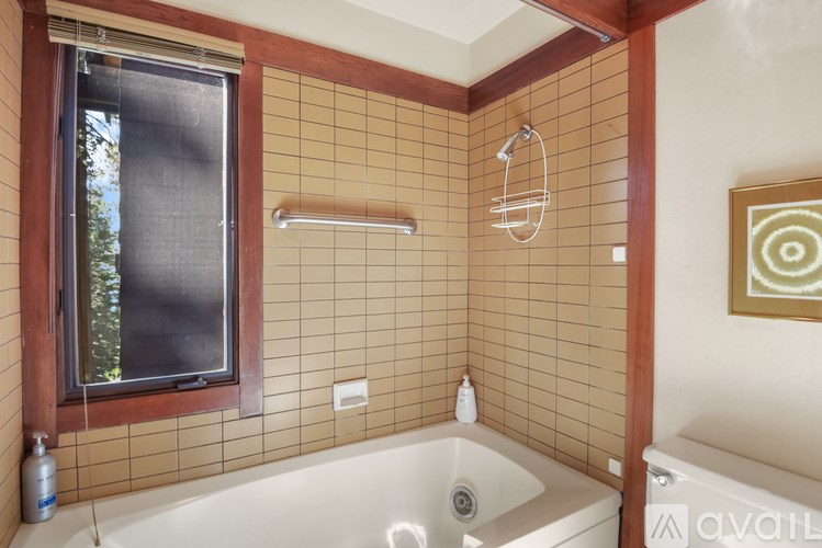 A bathroom with a tub and a window.