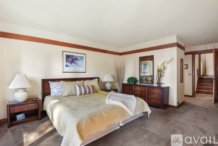 A bedroom with a large bed and a painting on the wall.