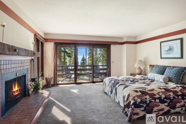 A bedroom with a fireplace and a large bed.