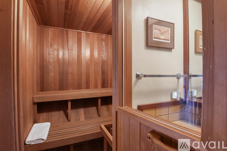 A wooden sauna with a mirror on the wall.
