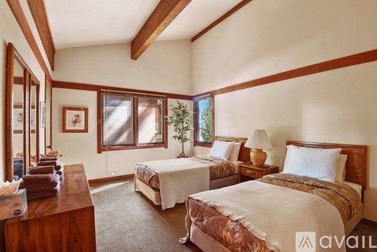 A room with two beds and a table with towels on it.