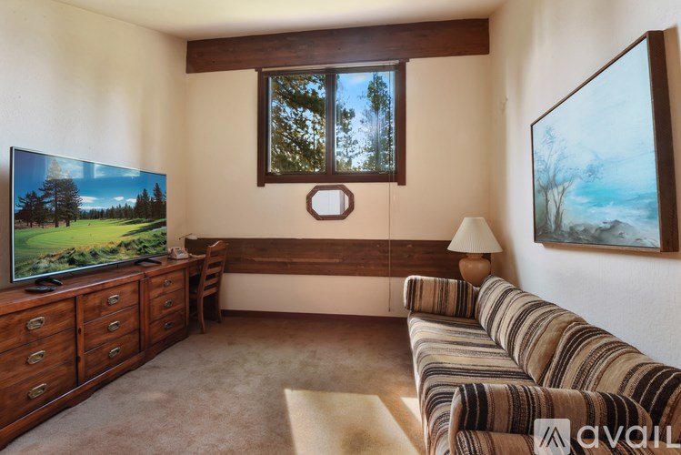 A living room with a couch, television, and a painting on the wall.