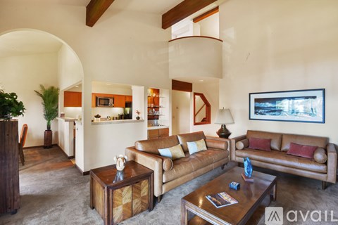 A living room with a brown leather couch and a wooden coffee table.