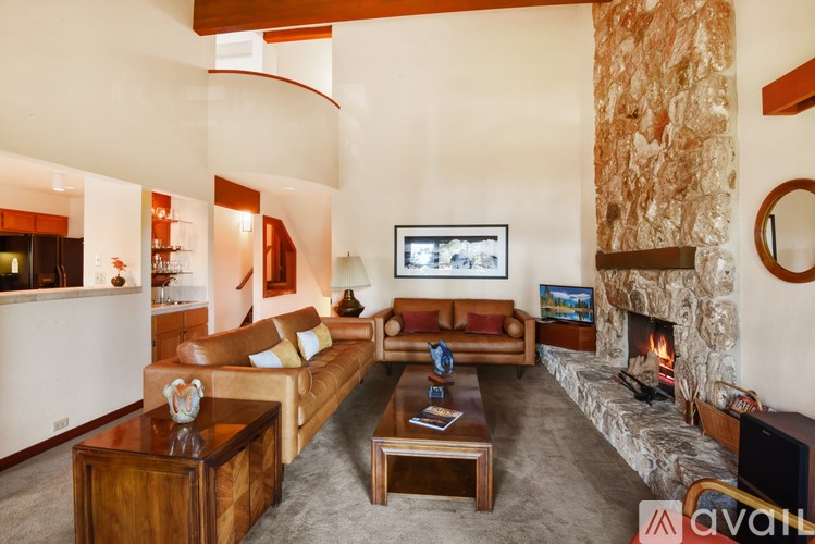 A living room with a stone fireplace and a television.