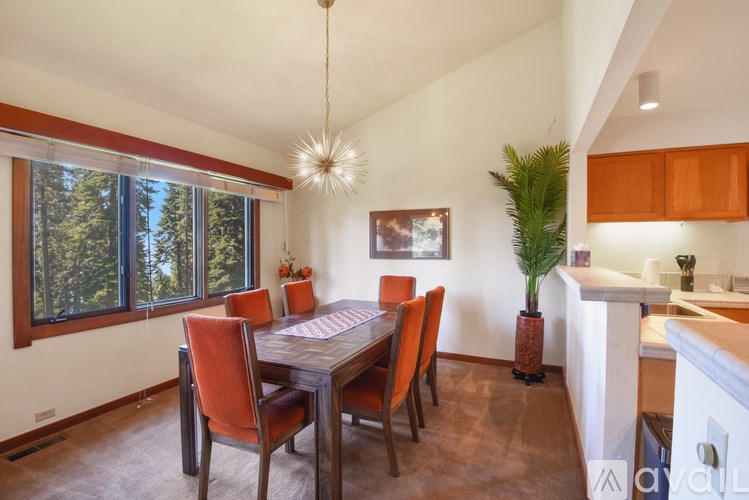 A dining room with a table and chairs.