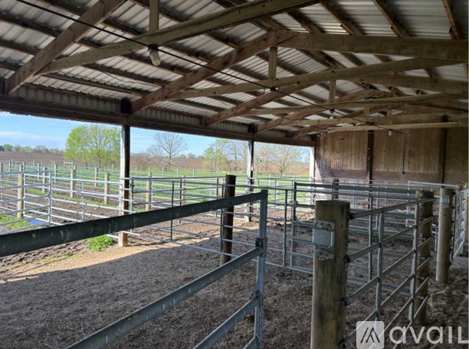 A large metal gate is on the left side of a wooden fence.