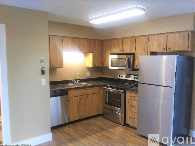 A kitchen with black appliances and white cabinets.
