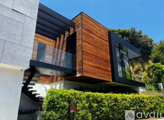 A modern house with a wooden exterior and glass windows.