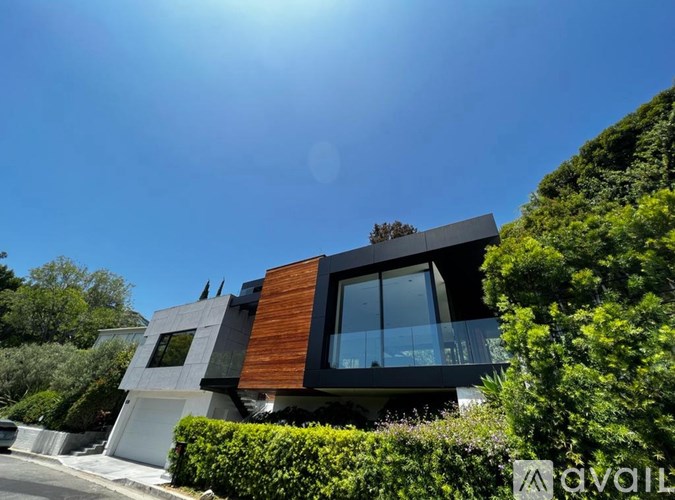 A modern house with a balcony and a glass door.